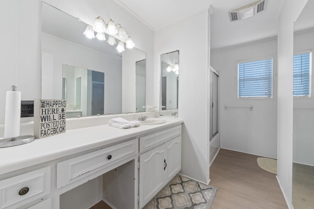 full bathroom featuring crown molding, vanity, wood finished floors, and visible vents
