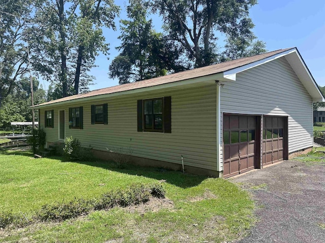 view of home's exterior featuring a detached garage and a lawn