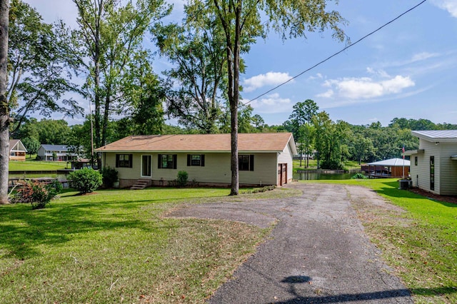 ranch-style house with a water view, cooling unit, and a front lawn