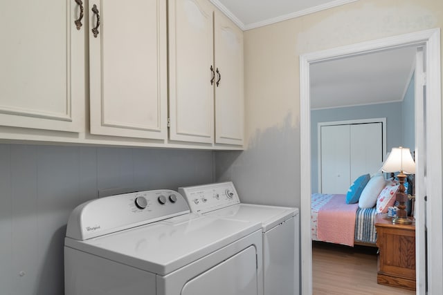 laundry area with crown molding, cabinet space, independent washer and dryer, and light wood finished floors