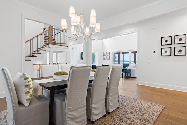 dining room with an inviting chandelier, crown molding, and wood-type flooring