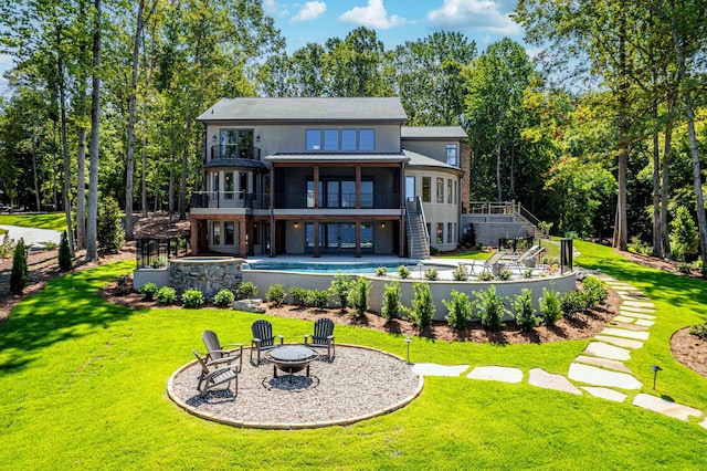 back of house featuring a yard, a patio area, and a fire pit