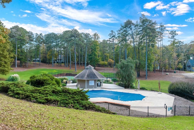 view of swimming pool featuring a patio, an outdoor structure, and a yard