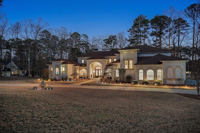 mediterranean / spanish-style home with a front yard