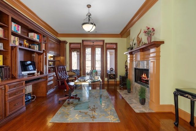 office space with dark wood finished floors, a fireplace, built in study area, and crown molding