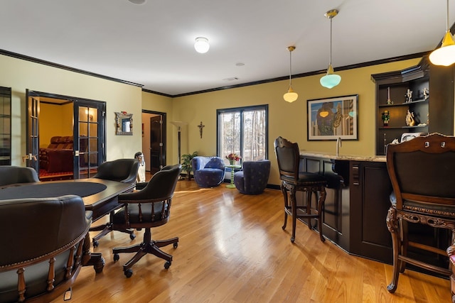 home office featuring french doors, light wood-style floors, and ornamental molding