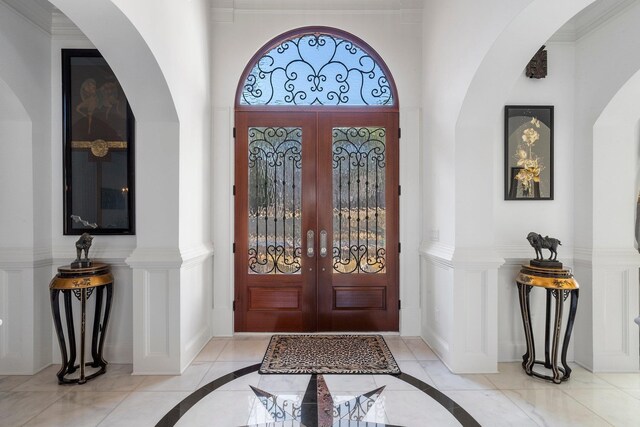 foyer entrance featuring french doors and baseboards