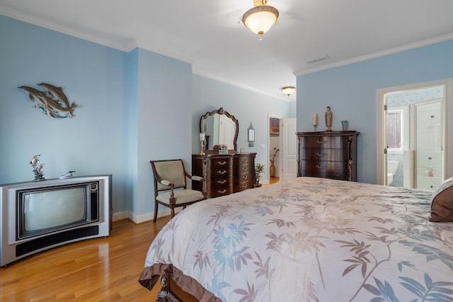 bedroom with visible vents, ensuite bath, wood finished floors, crown molding, and baseboards