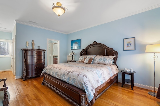 bedroom featuring ensuite bath, light wood-type flooring, baseboards, and ornamental molding