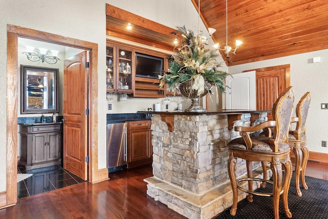 bar featuring high end fridge, a chandelier, wooden ceiling, vaulted ceiling, and dark wood-style floors