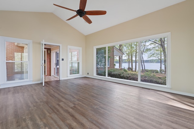 unfurnished living room featuring baseboards, ceiling fan, high vaulted ceiling, a water view, and dark wood finished floors