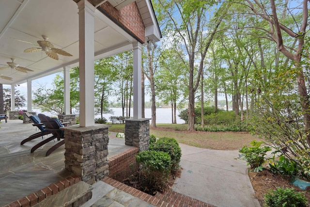 view of patio / terrace with covered porch, a water view, and ceiling fan