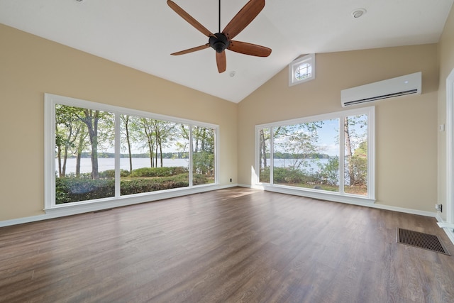 unfurnished living room featuring a ceiling fan, a wall mounted AC, a water view, and visible vents