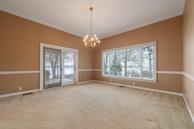 spare room with carpet floors, visible vents, a wealth of natural light, and an inviting chandelier