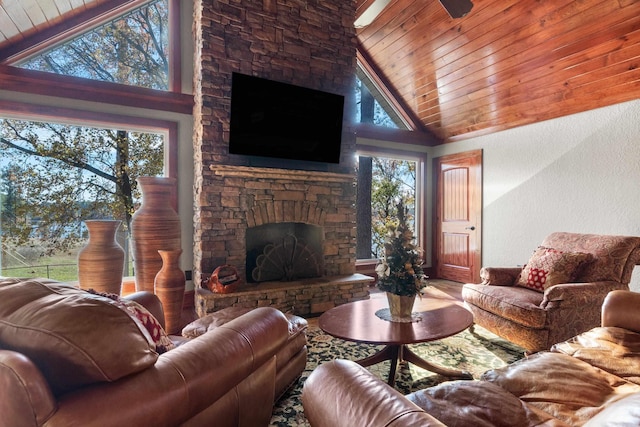 living area with a stone fireplace, plenty of natural light, wood ceiling, and high vaulted ceiling