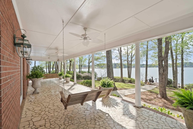 view of patio with a ceiling fan and a water view