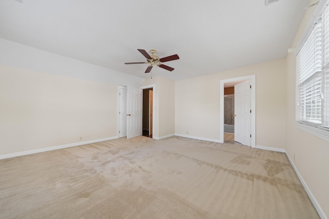 unfurnished bedroom featuring baseboards, light colored carpet, and ceiling fan