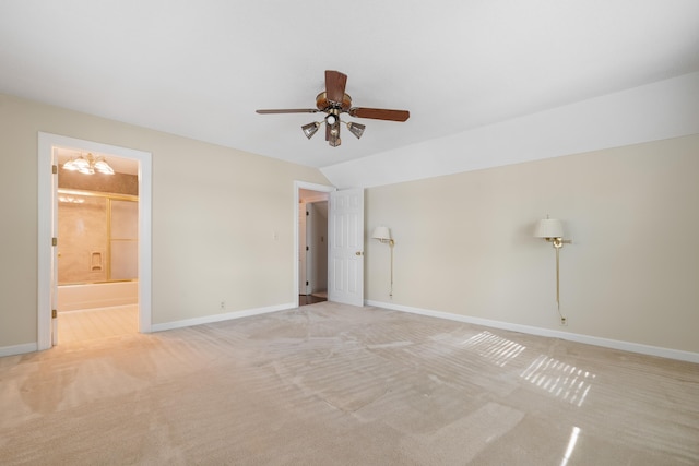unfurnished bedroom featuring baseboards, ensuite bathroom, ceiling fan with notable chandelier, and light carpet