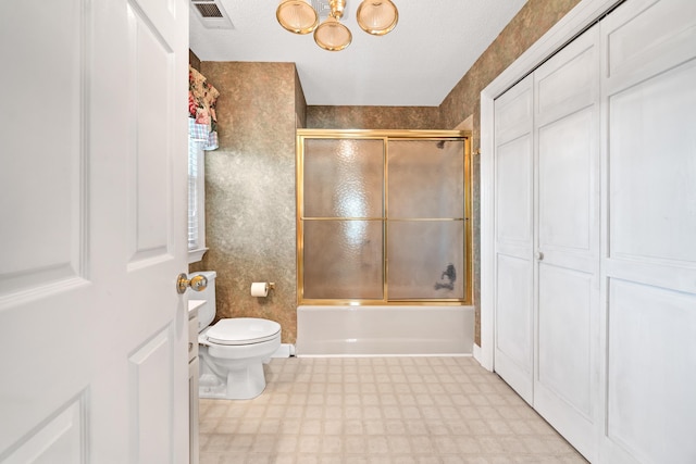 full bath featuring visible vents, tile patterned floors, bath / shower combo with glass door, toilet, and a notable chandelier