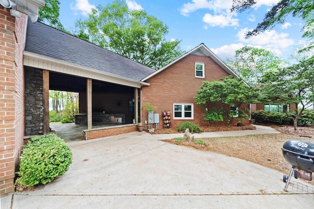 view of front of house with brick siding and roof with shingles