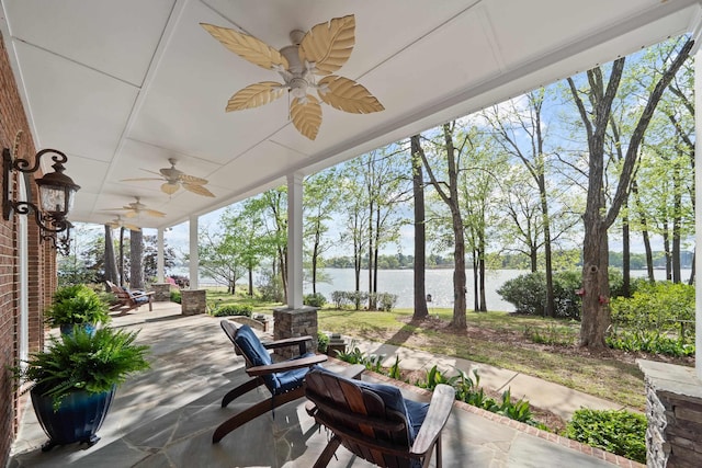 view of patio featuring a water view and ceiling fan