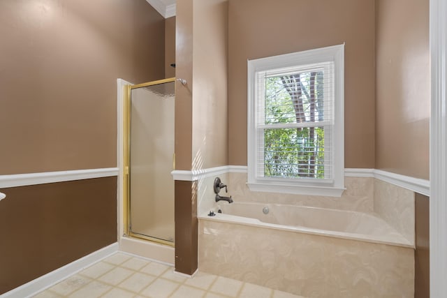 bathroom featuring a stall shower, a garden tub, and a wealth of natural light