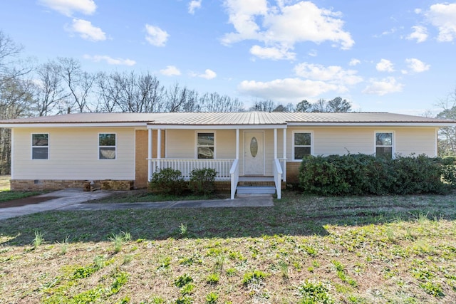 ranch-style home featuring covered porch and a front yard