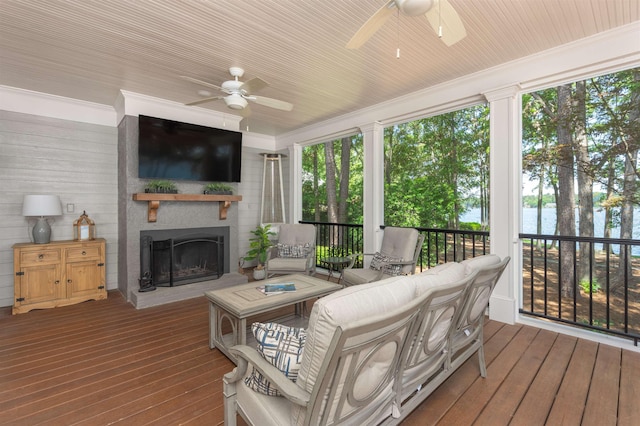 sunroom featuring a fireplace, a wealth of natural light, and ceiling fan