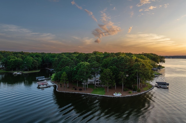 aerial view at dusk featuring a water view