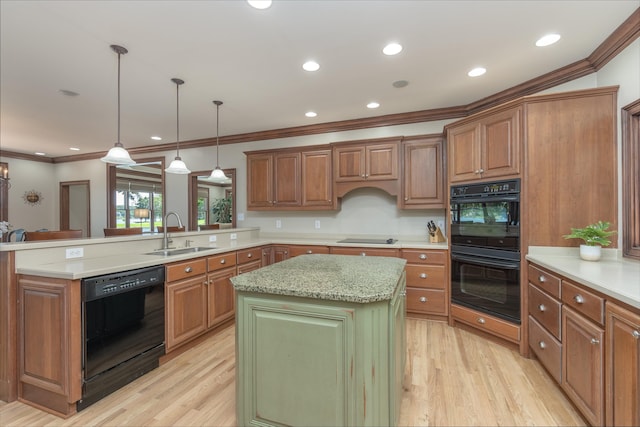 kitchen with pendant lighting, sink, a center island, black appliances, and kitchen peninsula