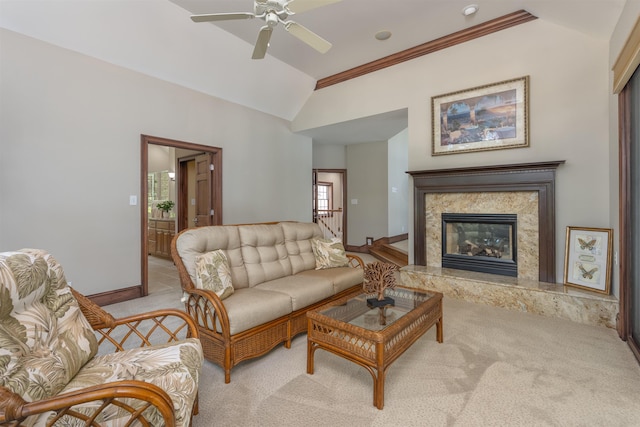 living room featuring lofted ceiling, crown molding, ceiling fan, a fireplace, and light carpet