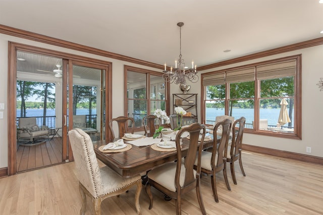 dining area with ornamental molding, light hardwood / wood-style floors, and a water view