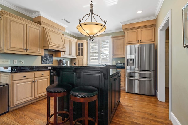 100 Indian Trl, Eatonton, GA 31024 - kitchen with visible vents, stainless steel fridge, ornamental molding, premium range hood, and a breakfast bar area
