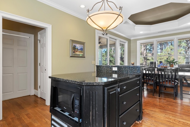100 Indian Trl, Eatonton, GA 31024 - kitchen with crown molding, dark cabinetry, a raised ceiling, light wood-style flooring, and black microwave
