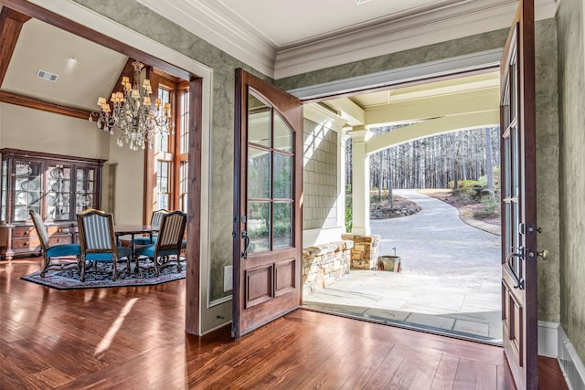 doorway with visible vents, a chandelier, ornamental molding, hardwood / wood-style floors, and french doors