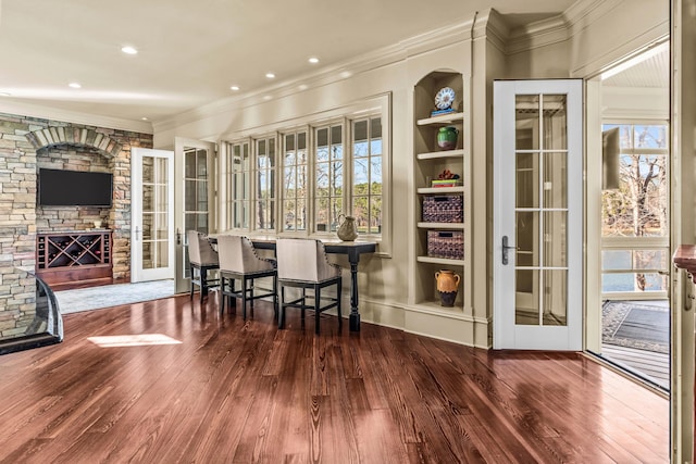 dining space featuring recessed lighting, ornamental molding, built in shelves, and wood finished floors