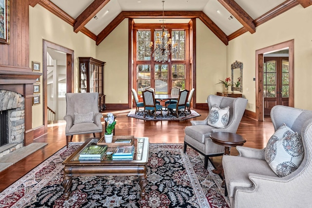 living area with beamed ceiling, a healthy amount of sunlight, and an inviting chandelier