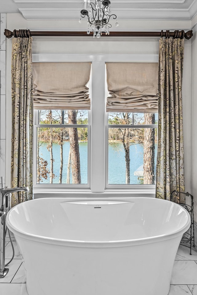 full bath with a water view, a notable chandelier, marble finish floor, and a freestanding bath