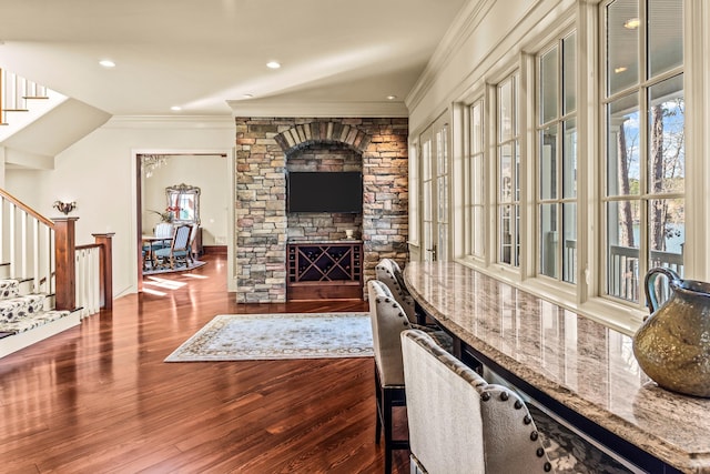 living area with recessed lighting, wood finished floors, stairs, and crown molding