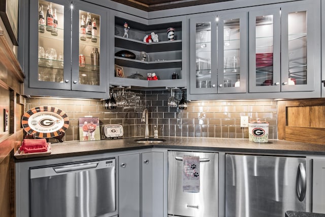 bar featuring tasteful backsplash, a sink, refrigerator, and stainless steel dishwasher