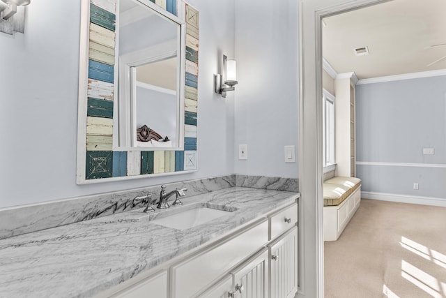 bathroom with vanity, crown molding, baseboards, and visible vents