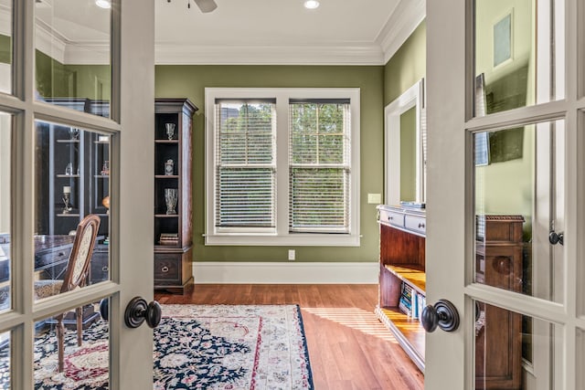 interior space featuring crown molding, wood finished floors, and baseboards