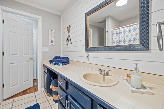 bathroom featuring vanity, tile patterned floors, and wooden walls