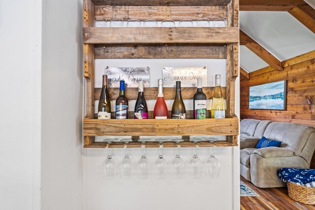 bar featuring wood-type flooring, beam ceiling, and wood walls