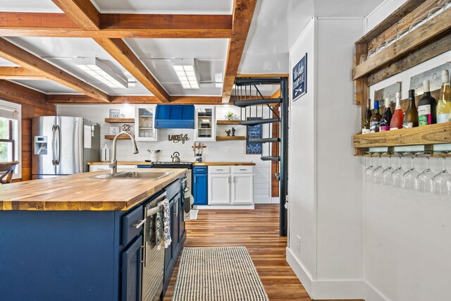 kitchen featuring blue cabinets, sink, butcher block countertops, stainless steel fridge with ice dispenser, and white cabinets