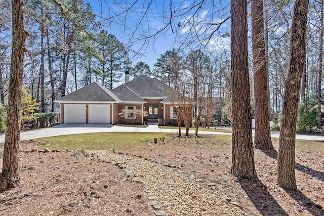 view of front of home with driveway, brick siding, a front lawn, and an attached garage