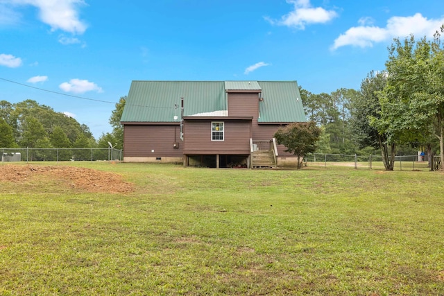 back of property featuring a wooden deck and a yard