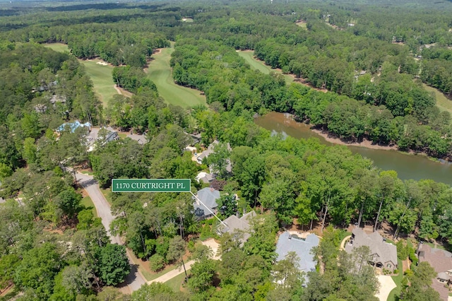 aerial view of property and surrounding area with a nearby body of water and a forest