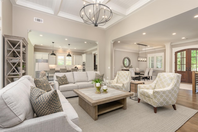 living area featuring a chandelier, ornamental molding, beamed ceiling, recessed lighting, and light wood finished floors