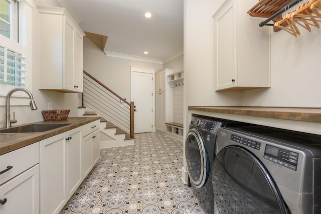 laundry area with washing machine and dryer, cabinet space, recessed lighting, and ornamental molding